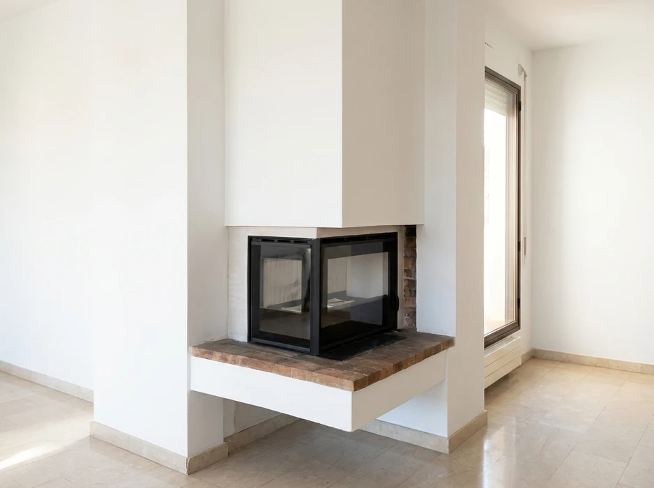 Pièce vide aux murs blancs avec cheminée d'angle contemporaine encastrée
