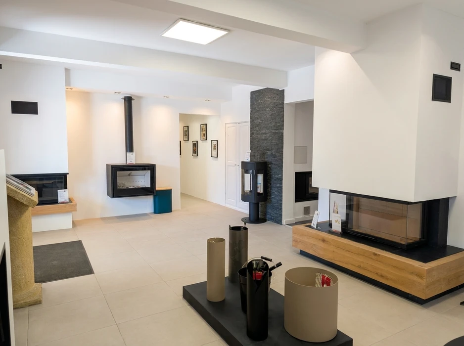 Showroom de cheminées et poêles modernes, sol carrelé blanc, murs blancs épurés